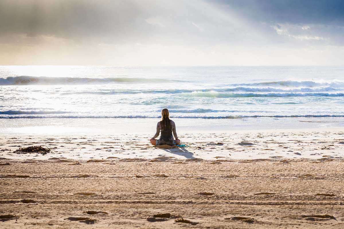 woman sitting on seashore 