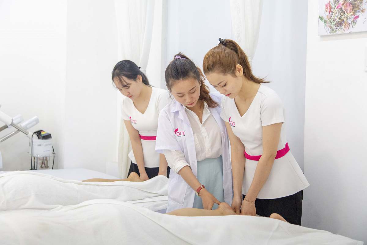person one woman assisting another woman in massaging massage