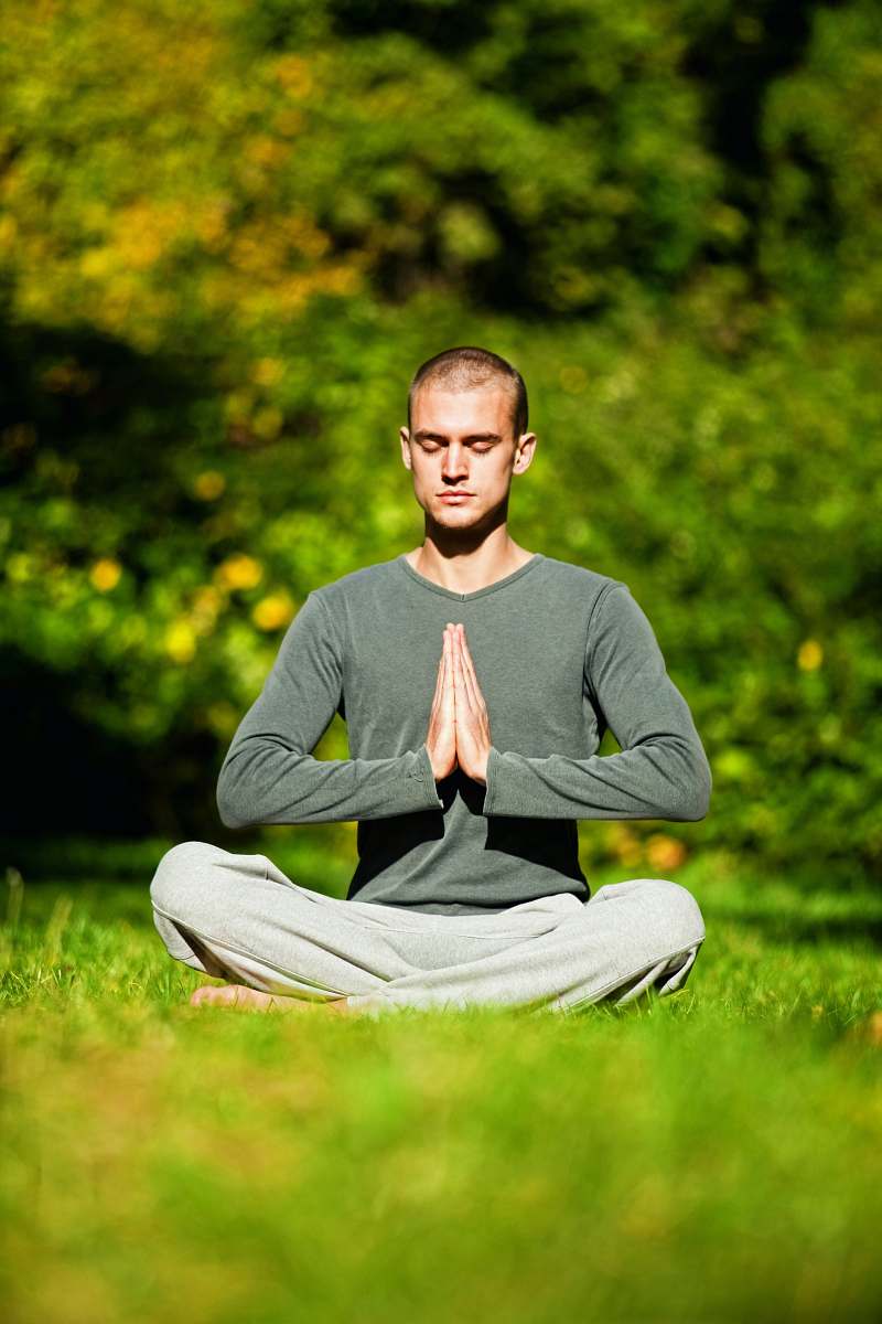 exercise man in gray long sleeve shirt and white pants sitting on green grass field during daytime fitness