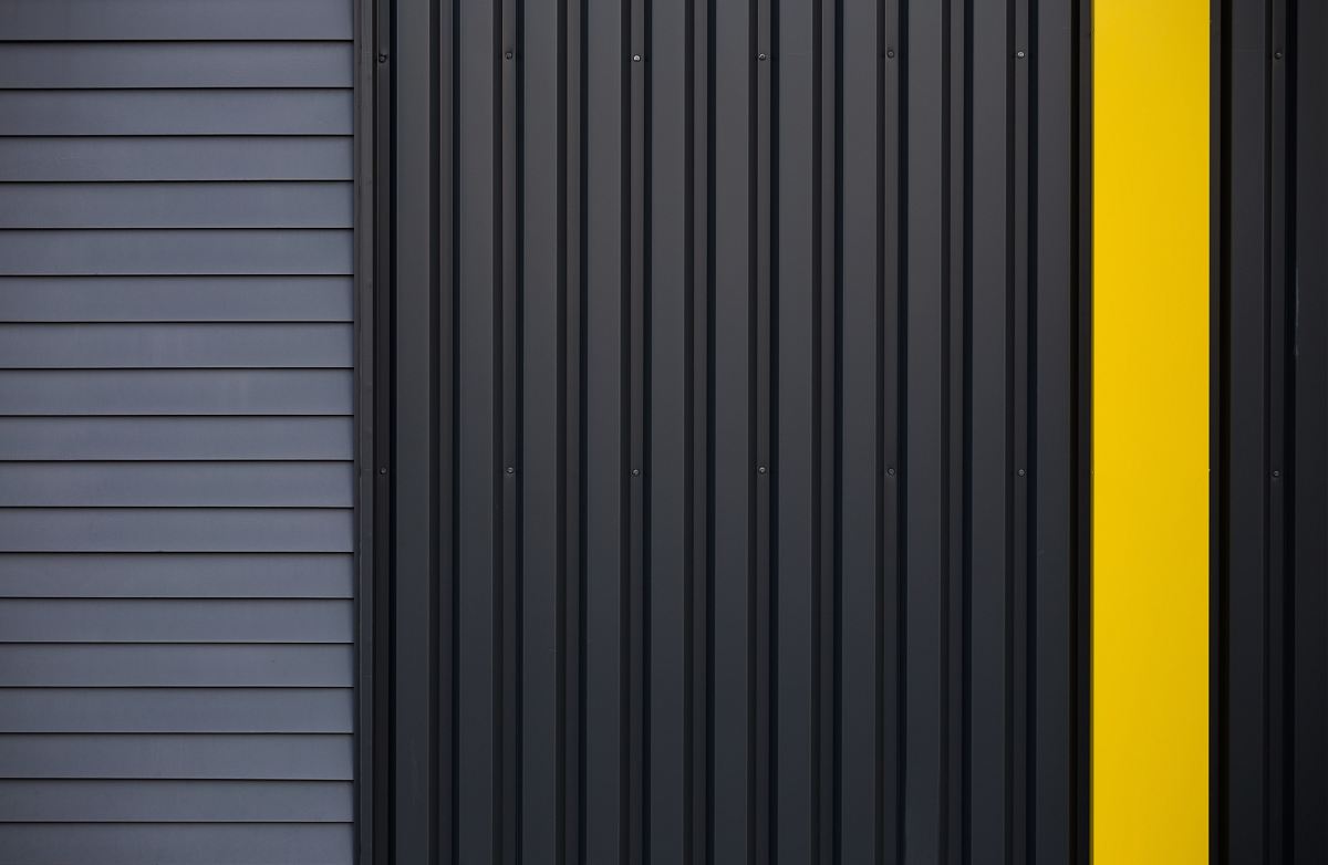 a yellow door on a black house