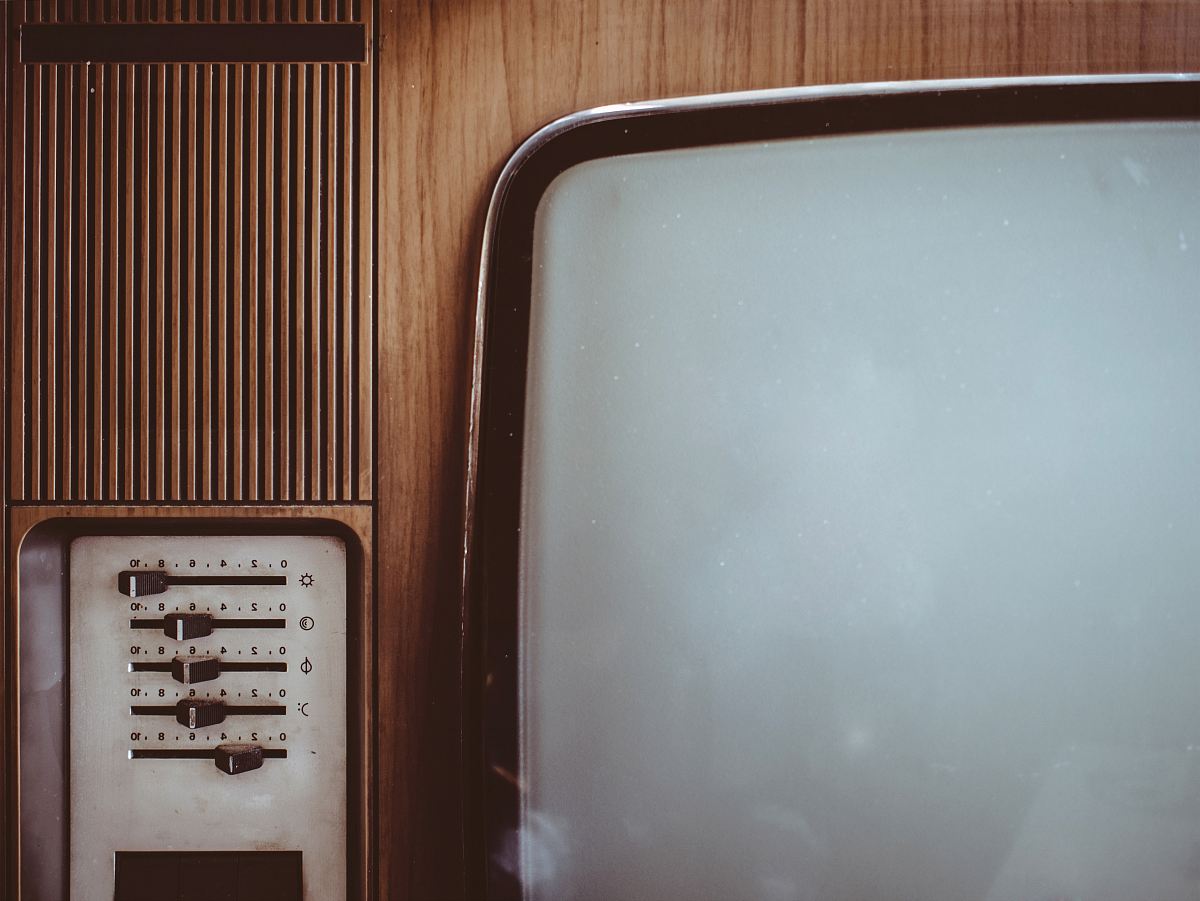 an old television set with a wooden wall