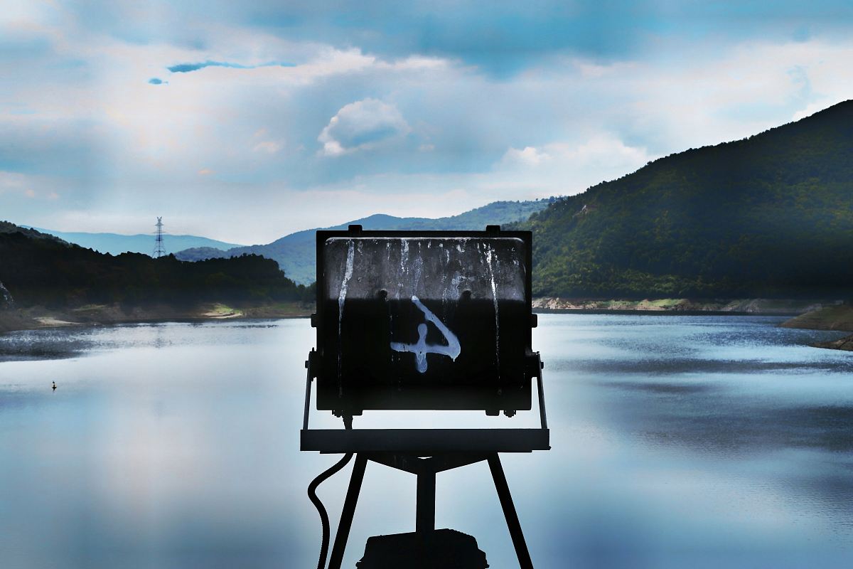 A sign marked with the number four over a lake