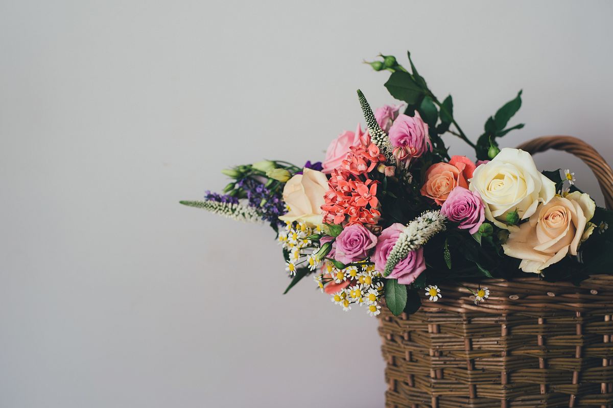 assorted-color flowers on brown wicker basket