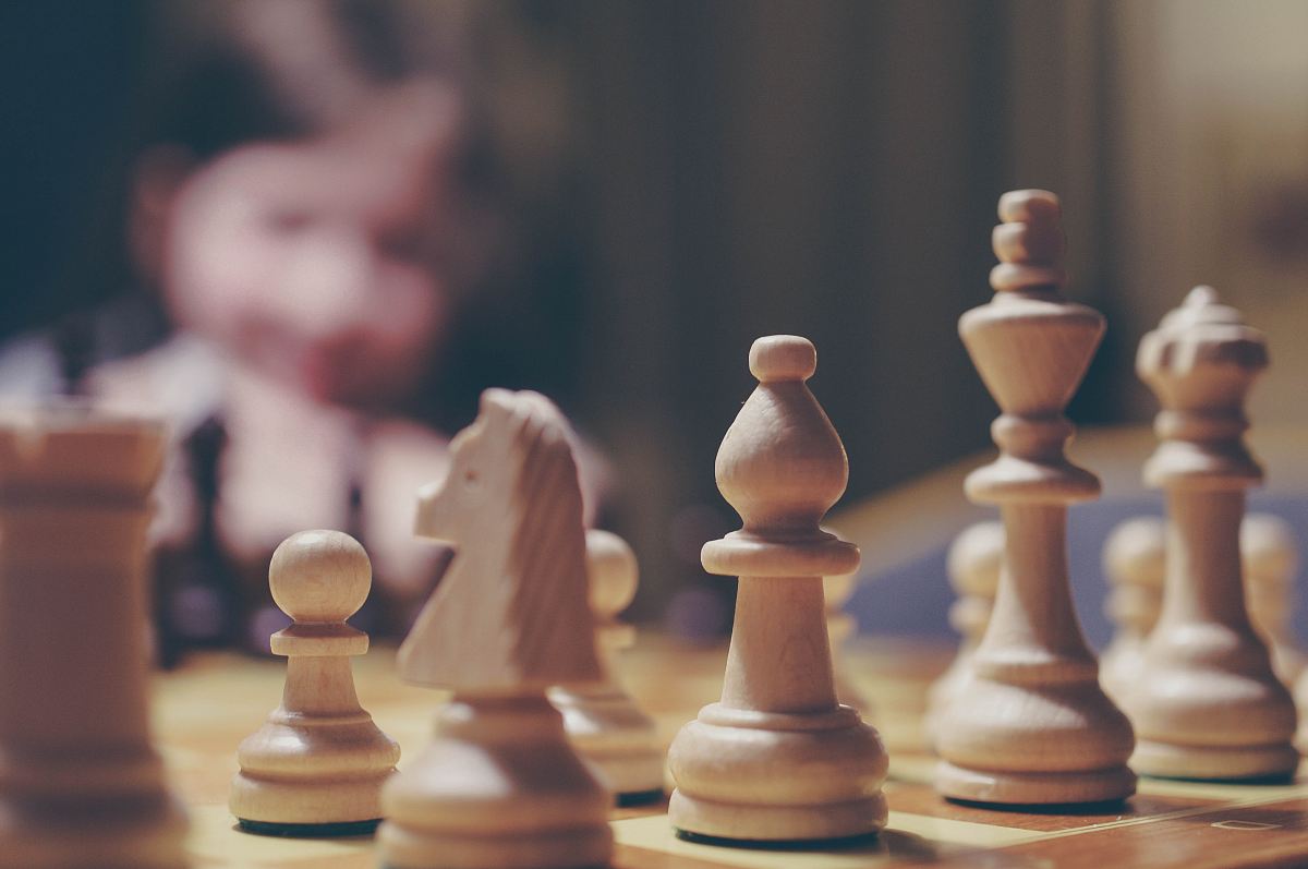 beige chess piece on board in selective focus photography