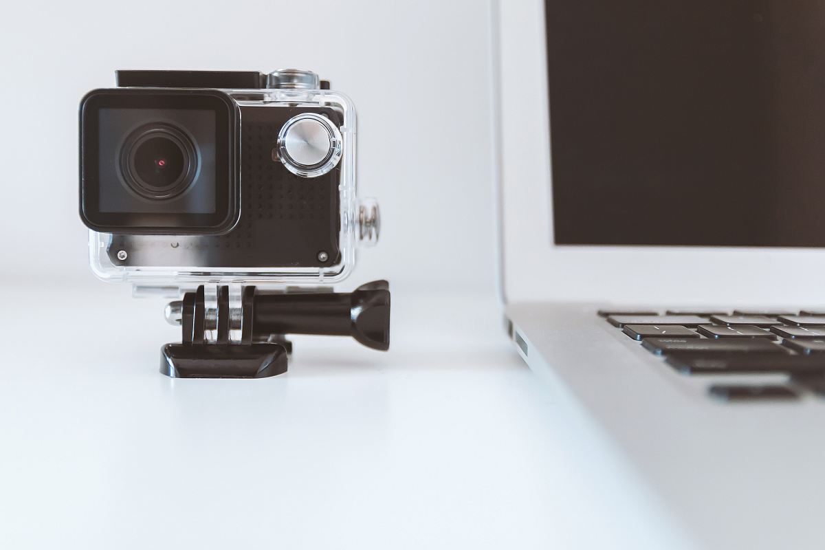 black action camera beside white laptop