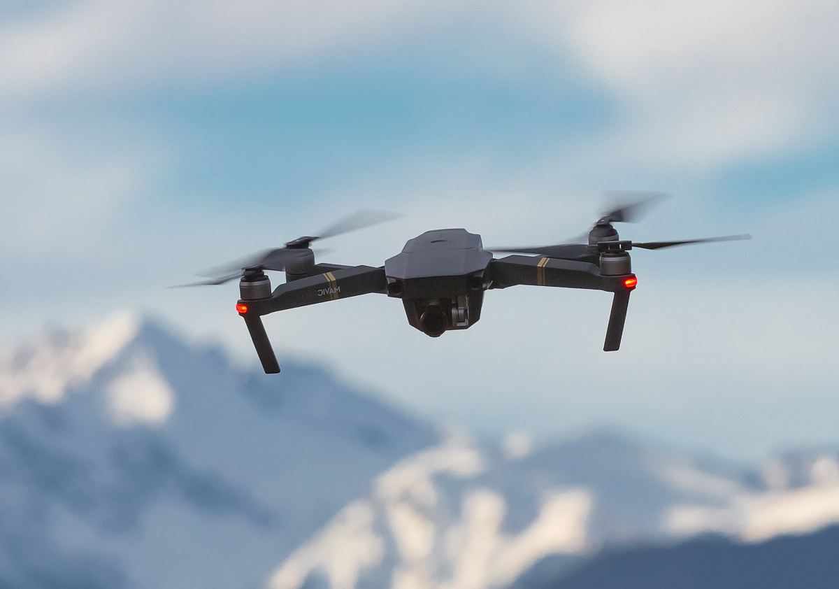 black drone quadcopter on air
