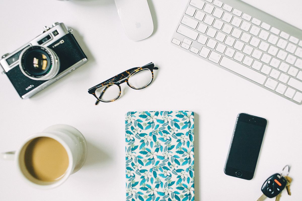 black frame eyeglasses beside black and gray SLR camera