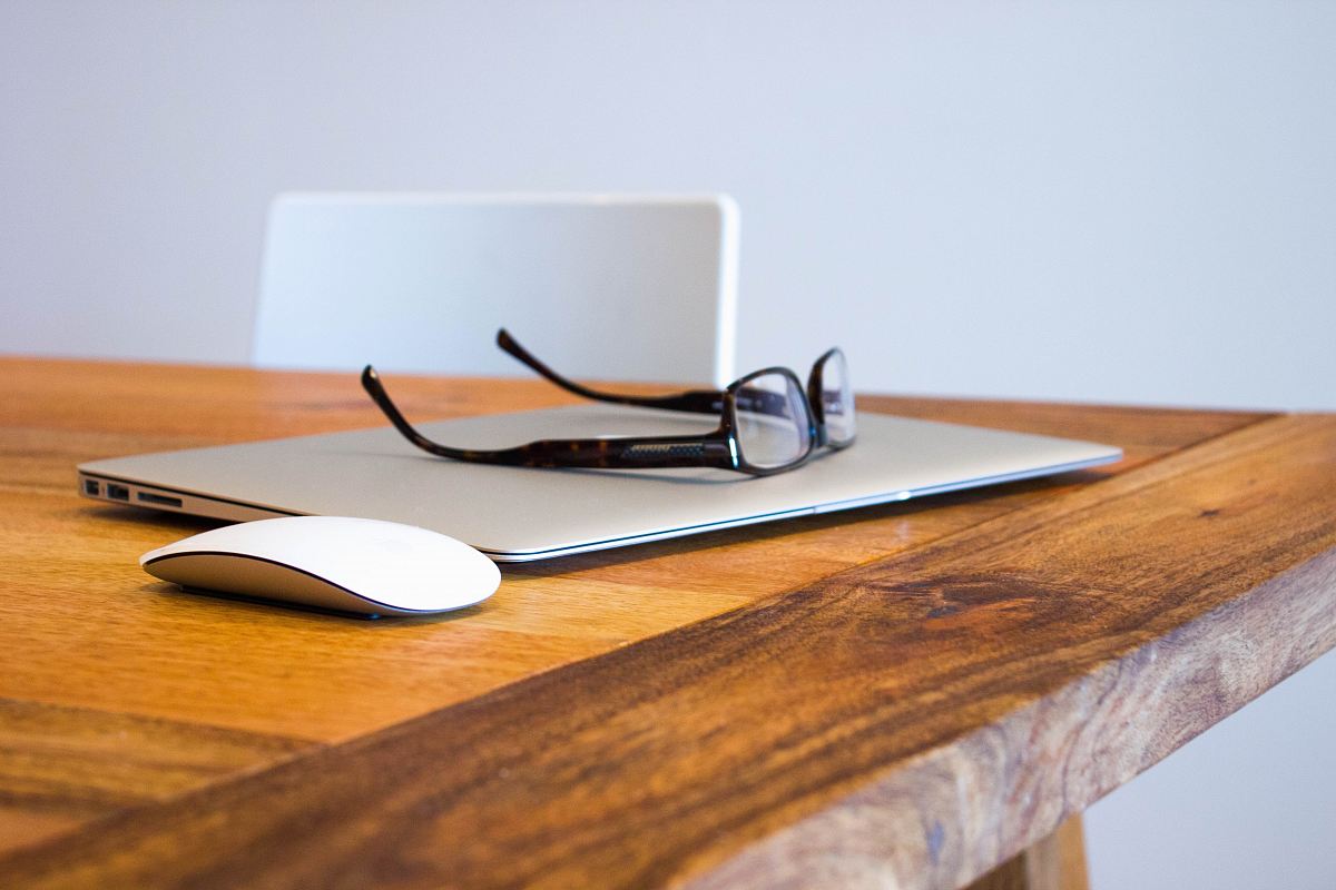 black framed eyeglasses on gray laptop computer