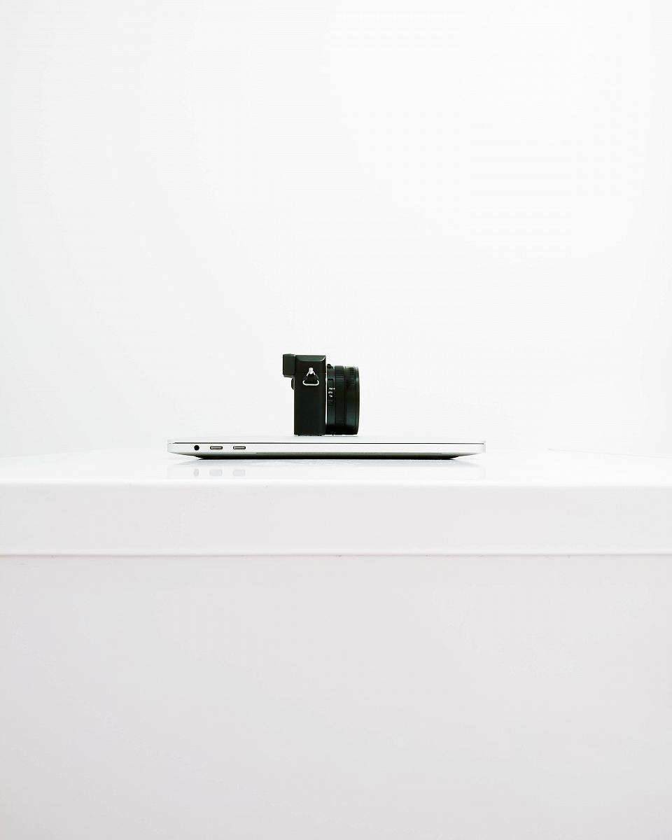 black mirrorless camera on top of MacBook