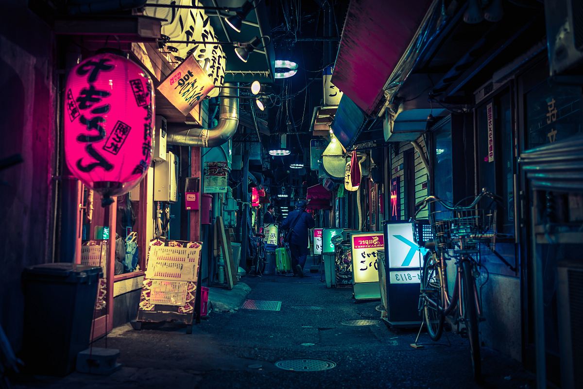 black pathway towards city buildings during nighttime