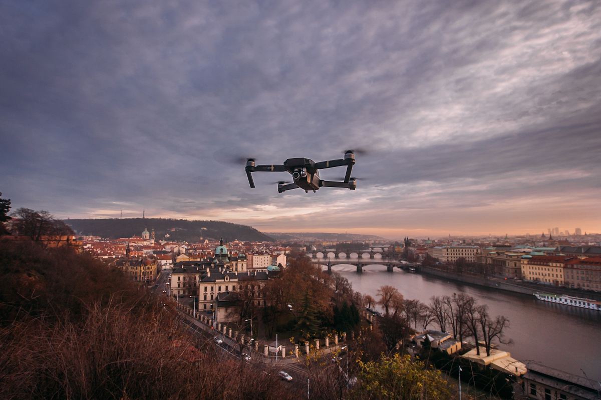 black quadcopter drone flying over the hill during daytime
