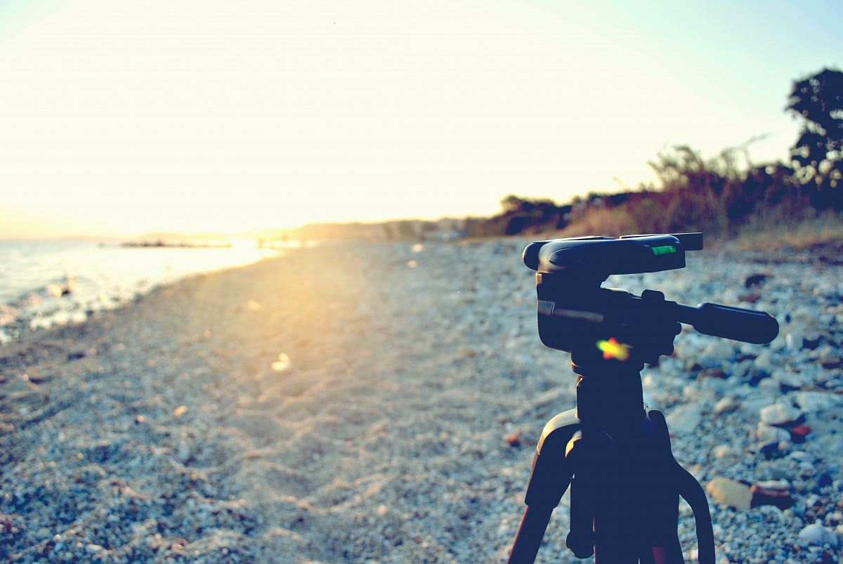 black tripod stand near shore during daytime