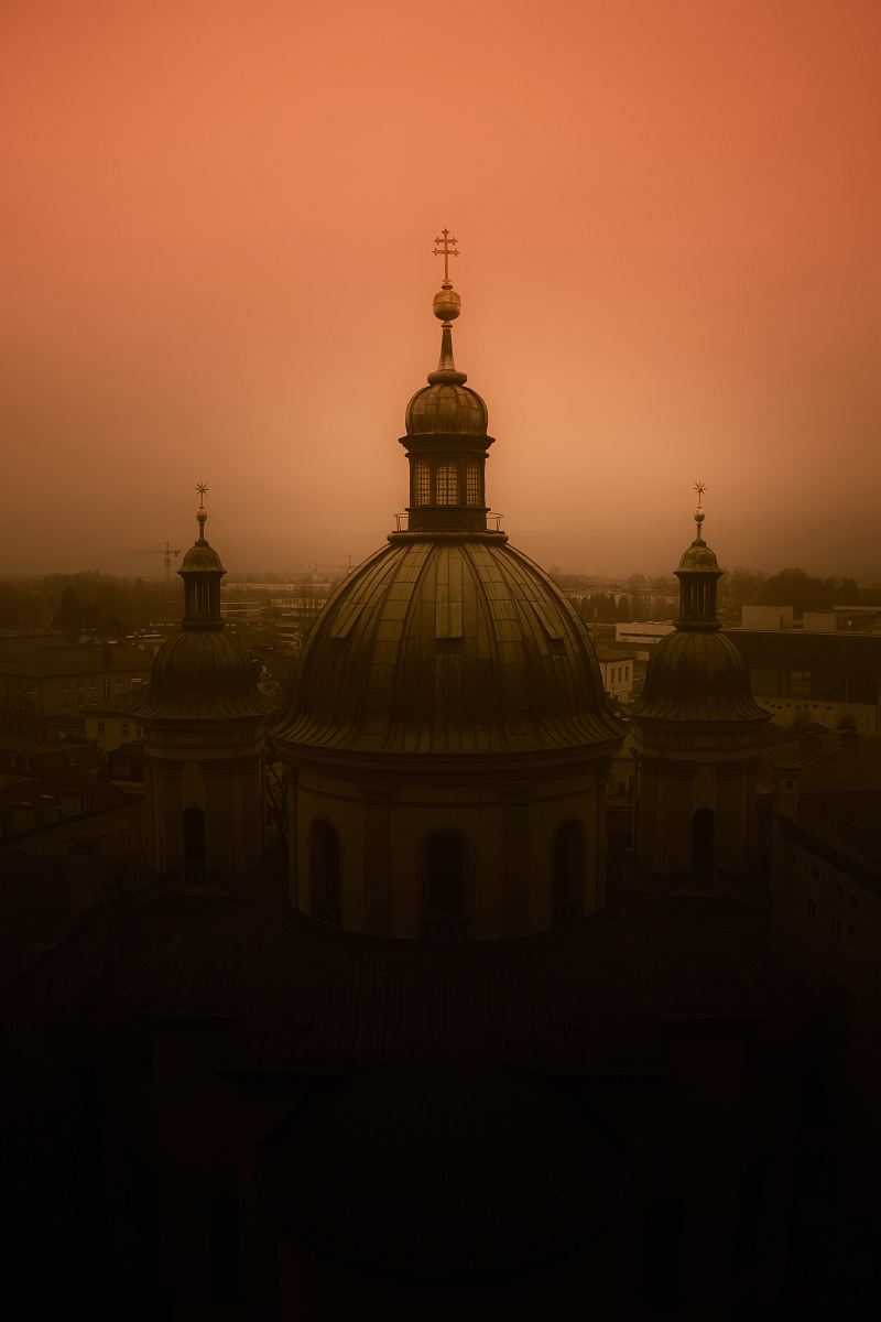 Experience the breathtaking beauty of a grand cathedral silhouetted against a dramatic red sky, creating a stunning contrast that captivates the eye. This striking image evokes a sense of wonder and spirituality, making it perfect for use in travel blogs, architectural reviews, or inspirational content. Capture the essence of urban landscapes transformed by nature's vibrant palette.