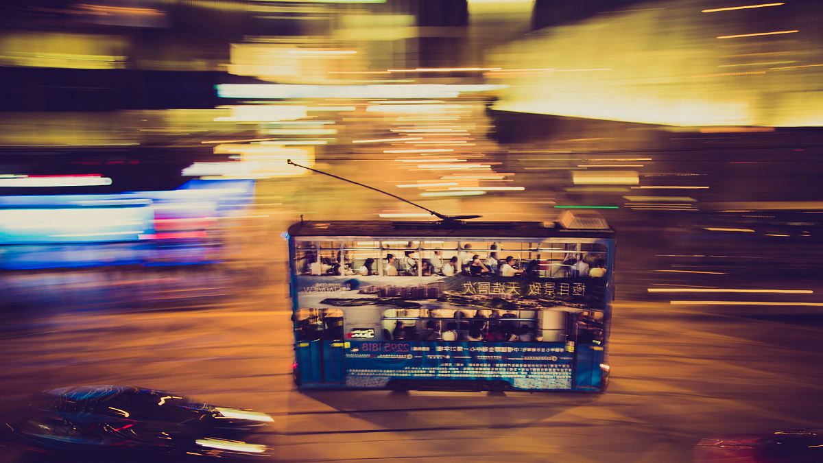 Double decker bus in motion moves through the night on Hong Kong Island