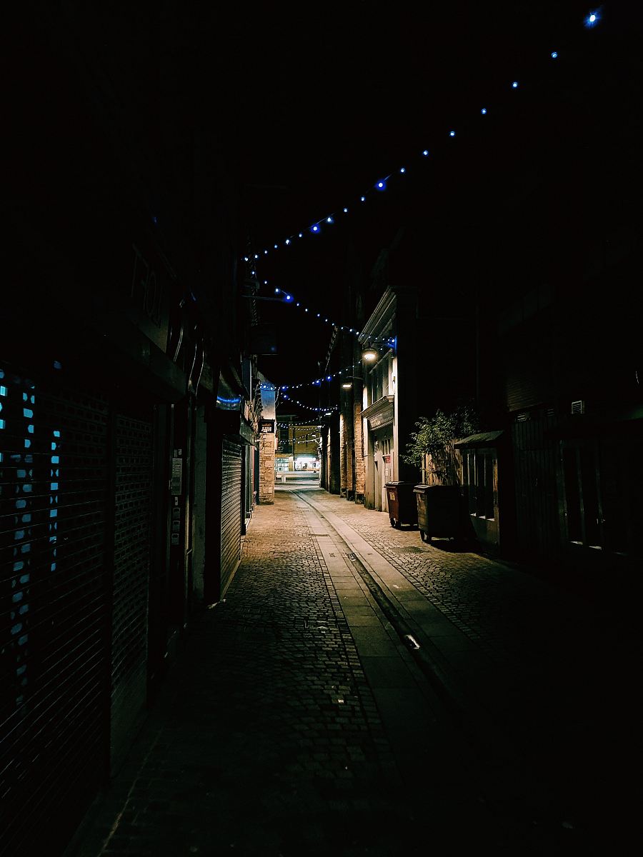 empty alley between houses and stores at night
