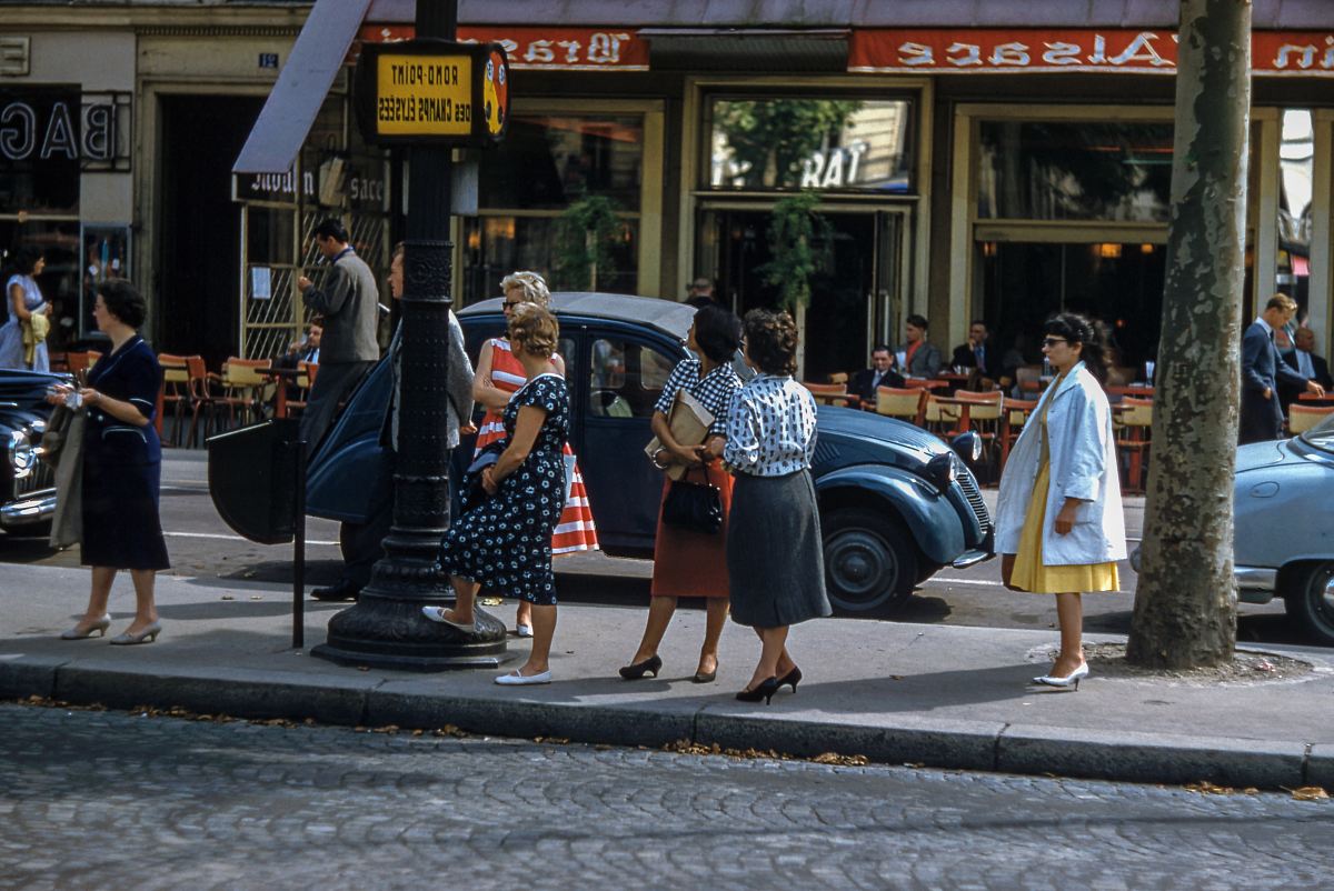 female women standing near black pole