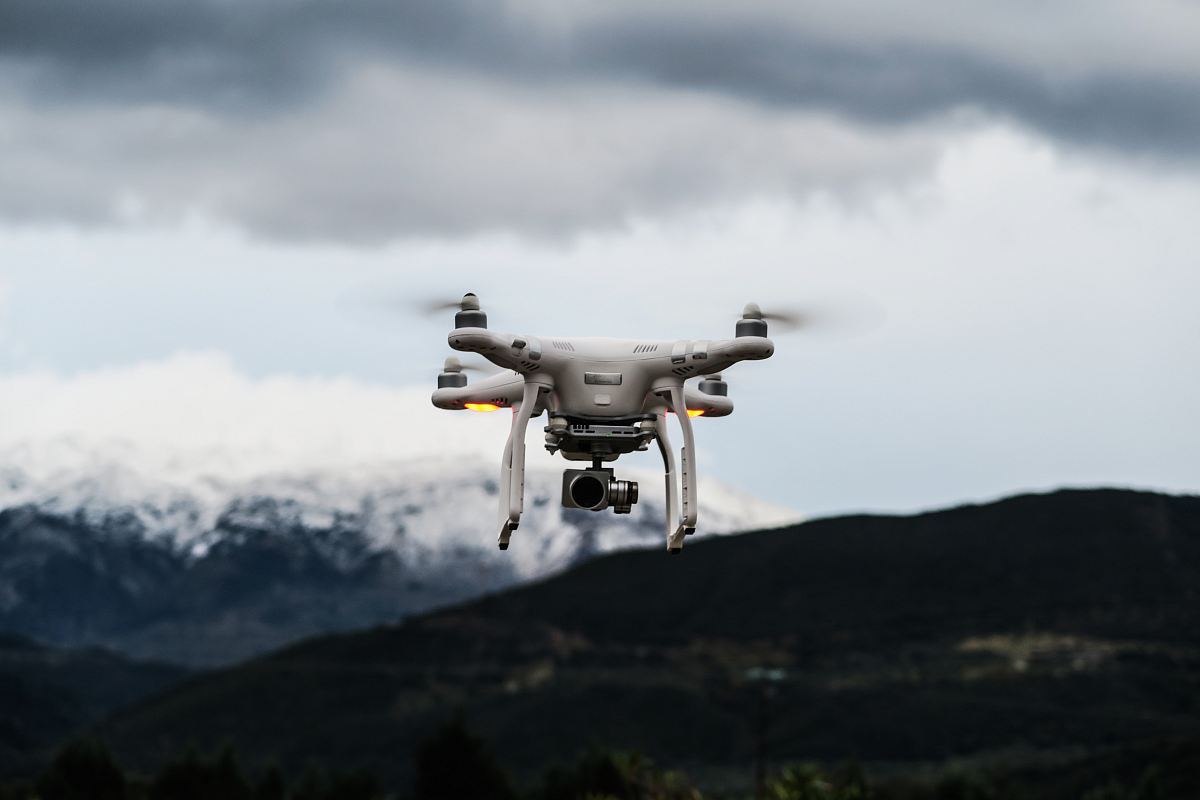 flying white quadcopter drone at daytime
