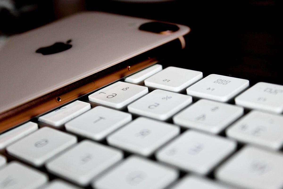 gold iPhone 8 plus beside keyboard