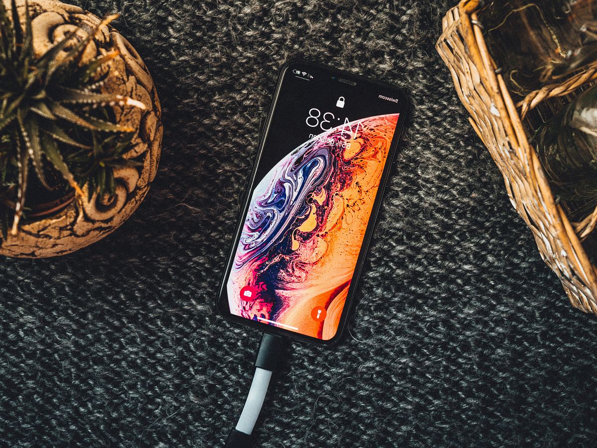 gold iPhone Xs on black textile