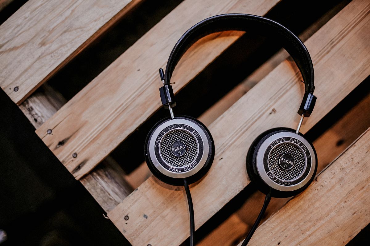 gray and black corded headphones on top of brown wooden surface
