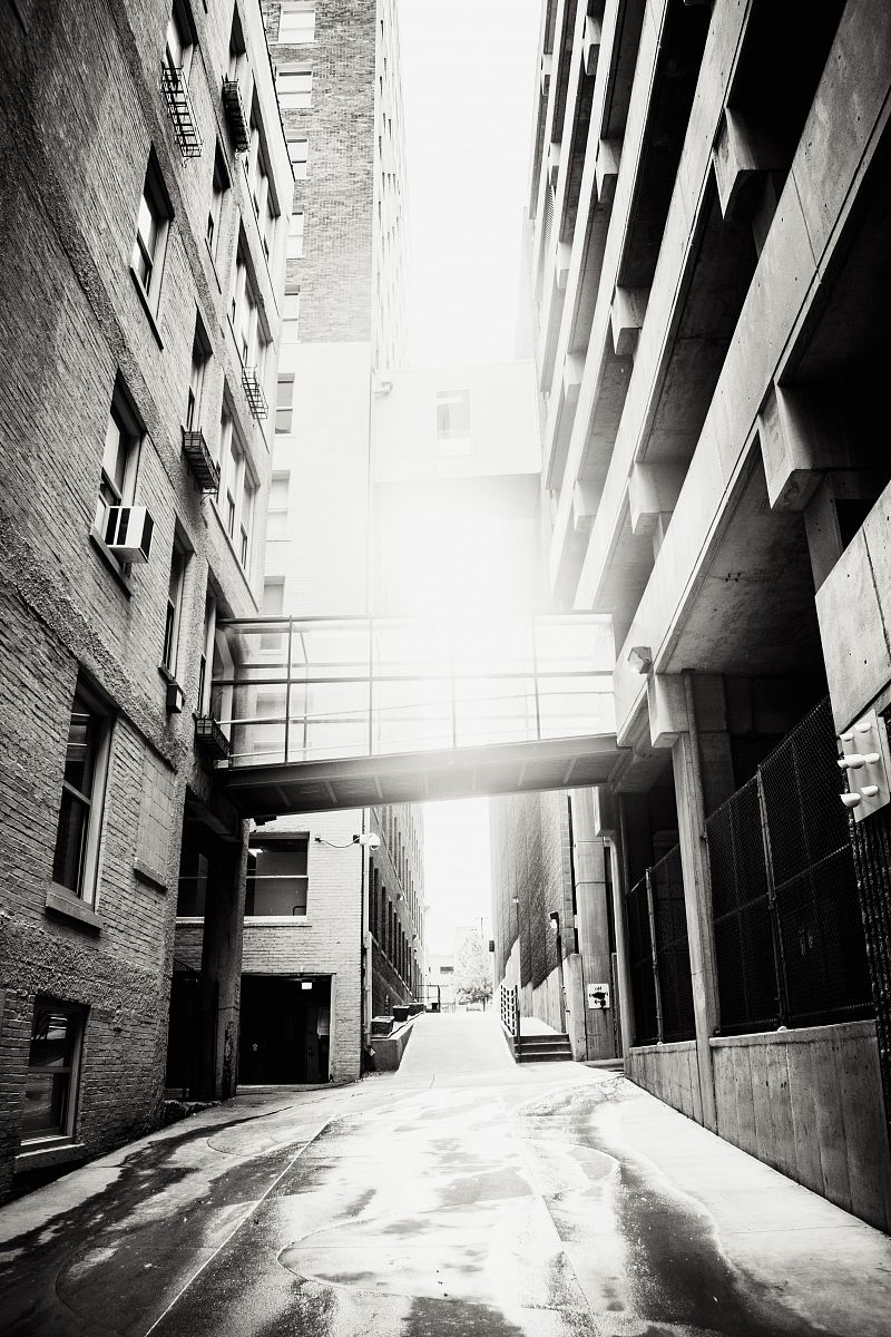 grayscale photo of pathway between buildings