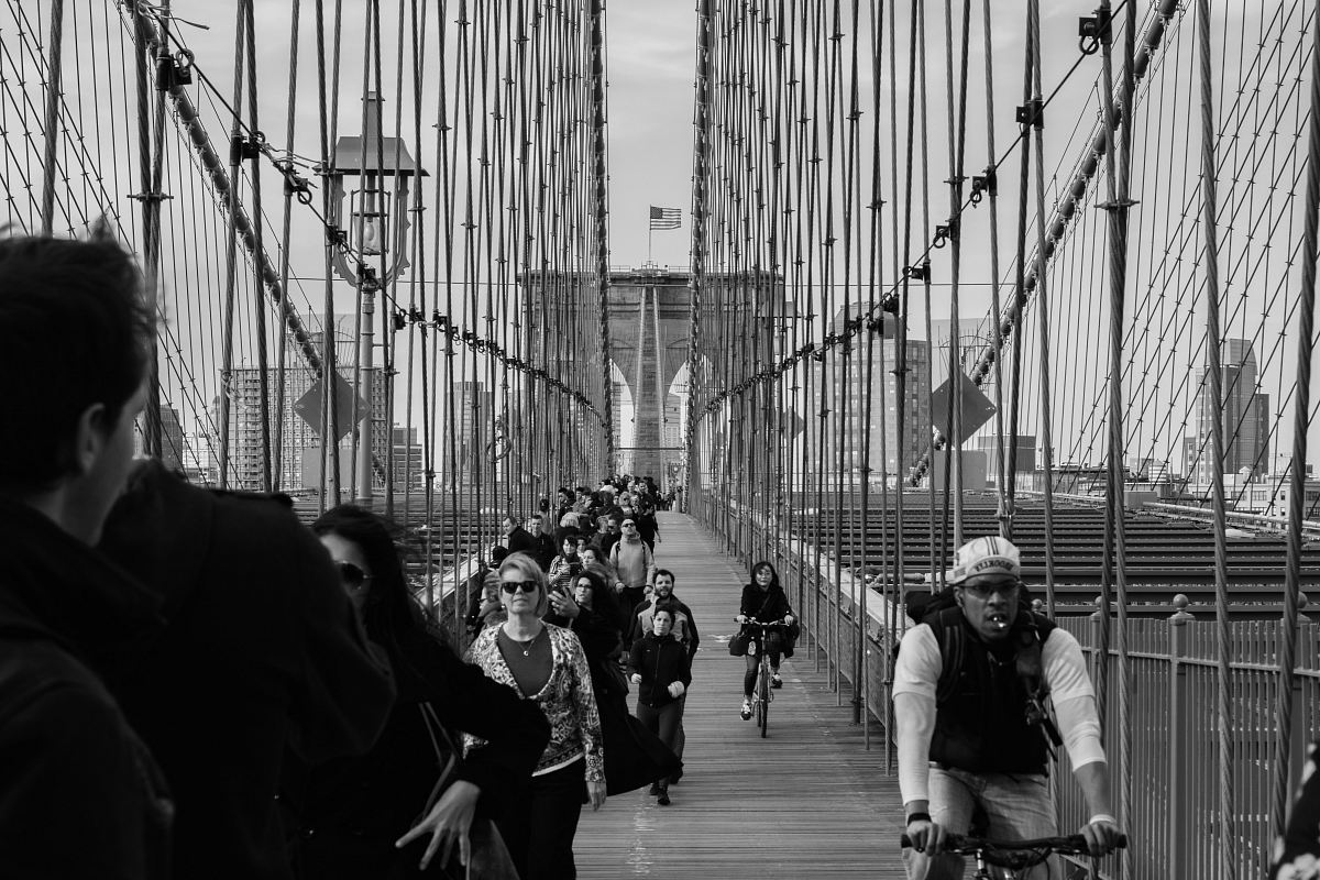 grayscale photo of people on bridge