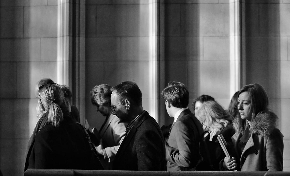grayscale photography of men and women walking near wall