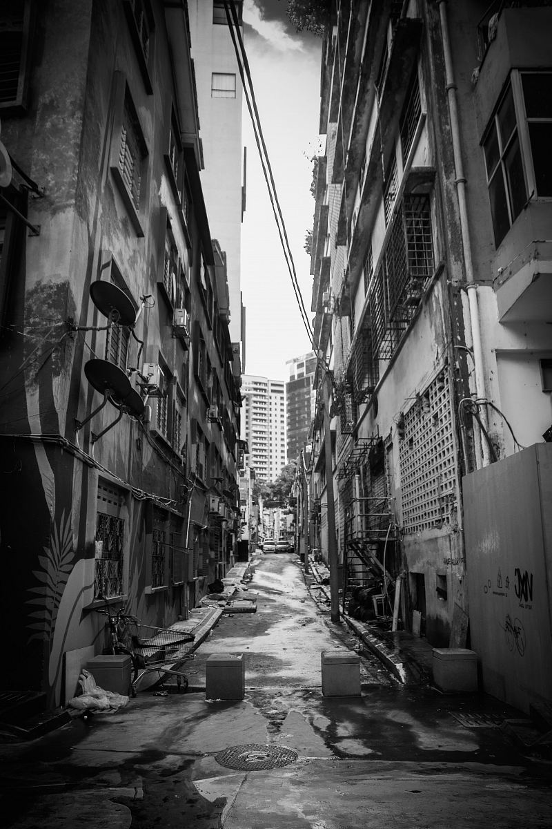 grayscale photography of pathway between buildings