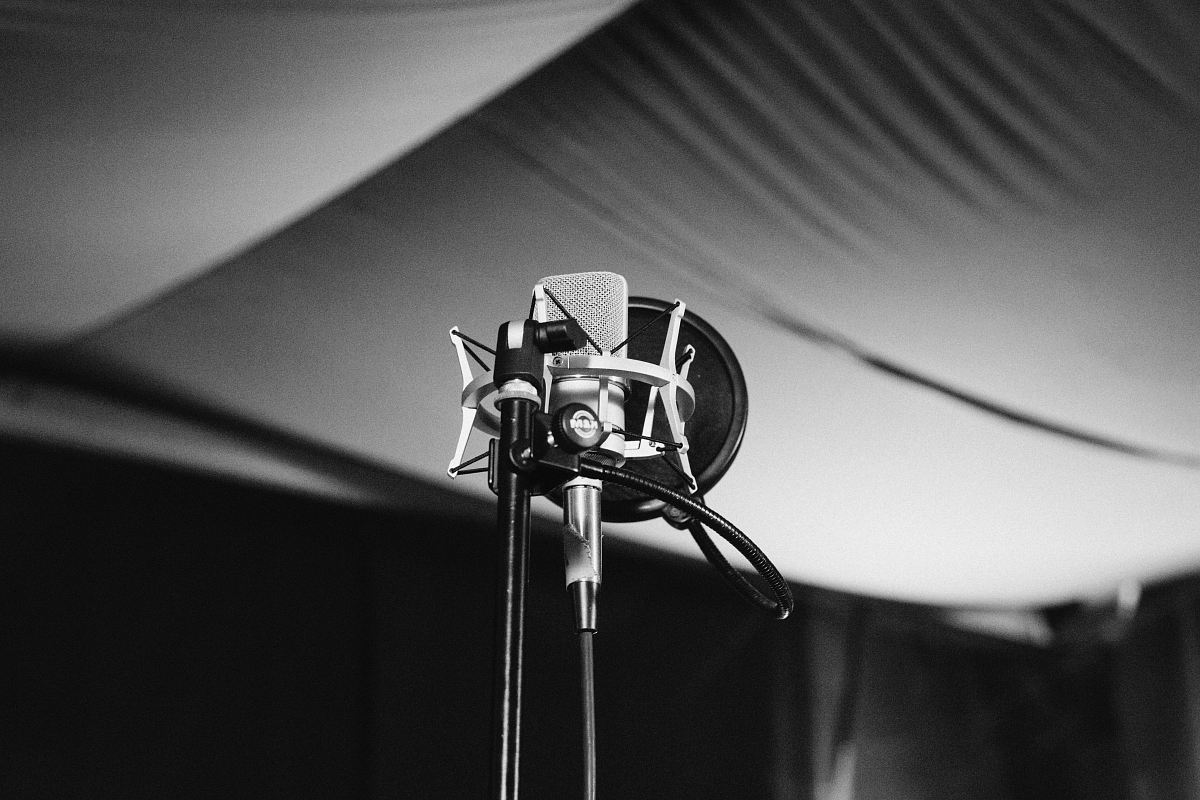 greyscale photo of condenser microphone with stand