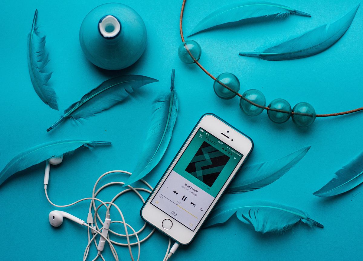 iPhone with EarPods beside feathers