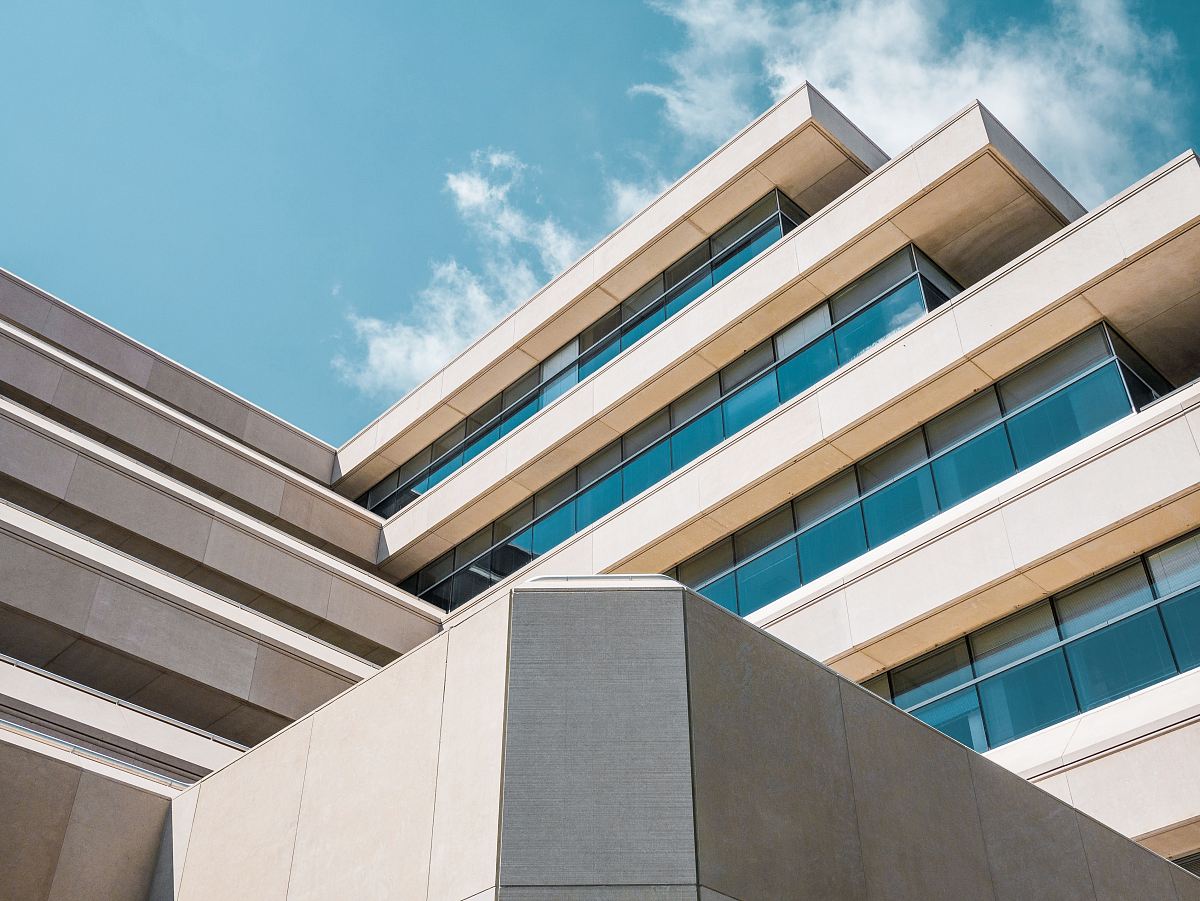 low angle photo of beige concrete building under cloudy sky