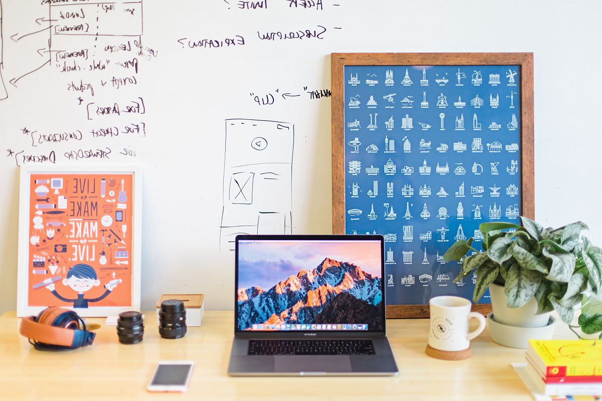 MacBook Pro on brown wooden table beside white mug