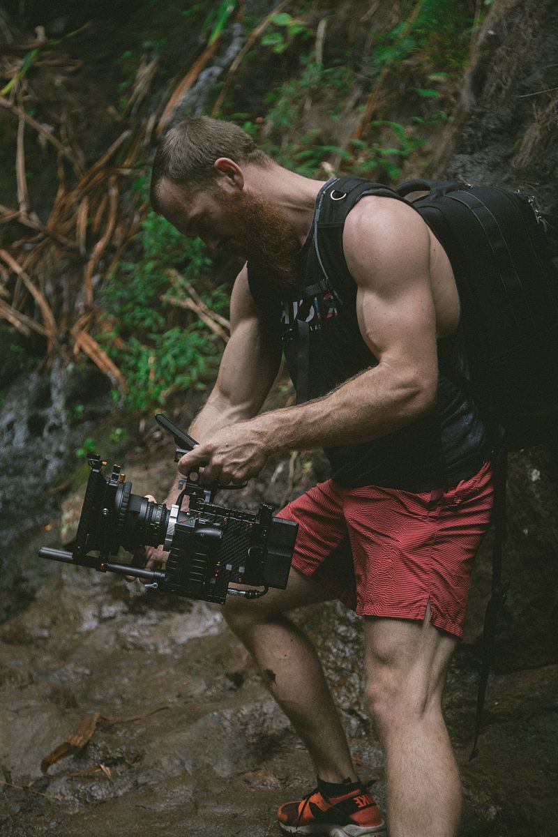 man holding black camera and backpack