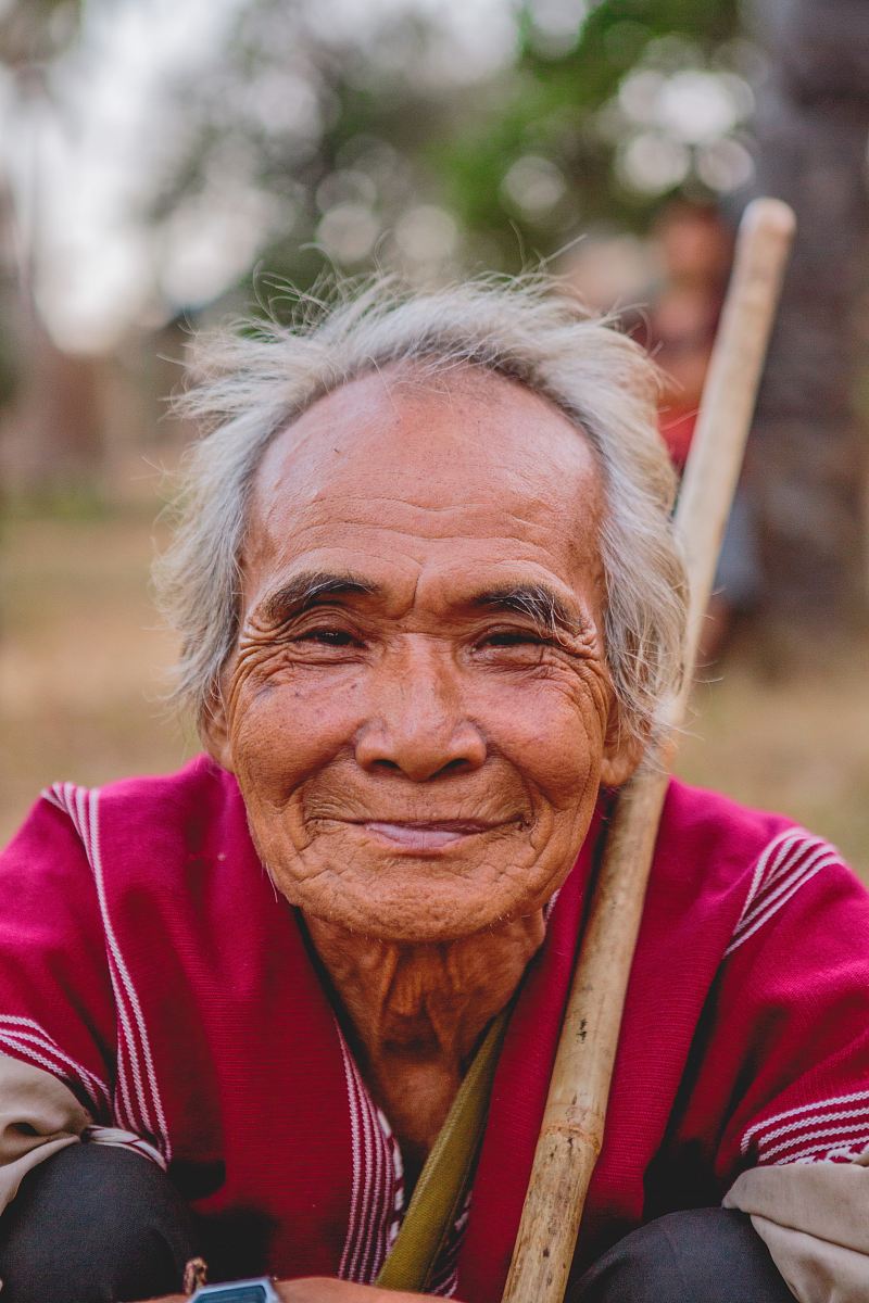 man holding brown stick smiling
