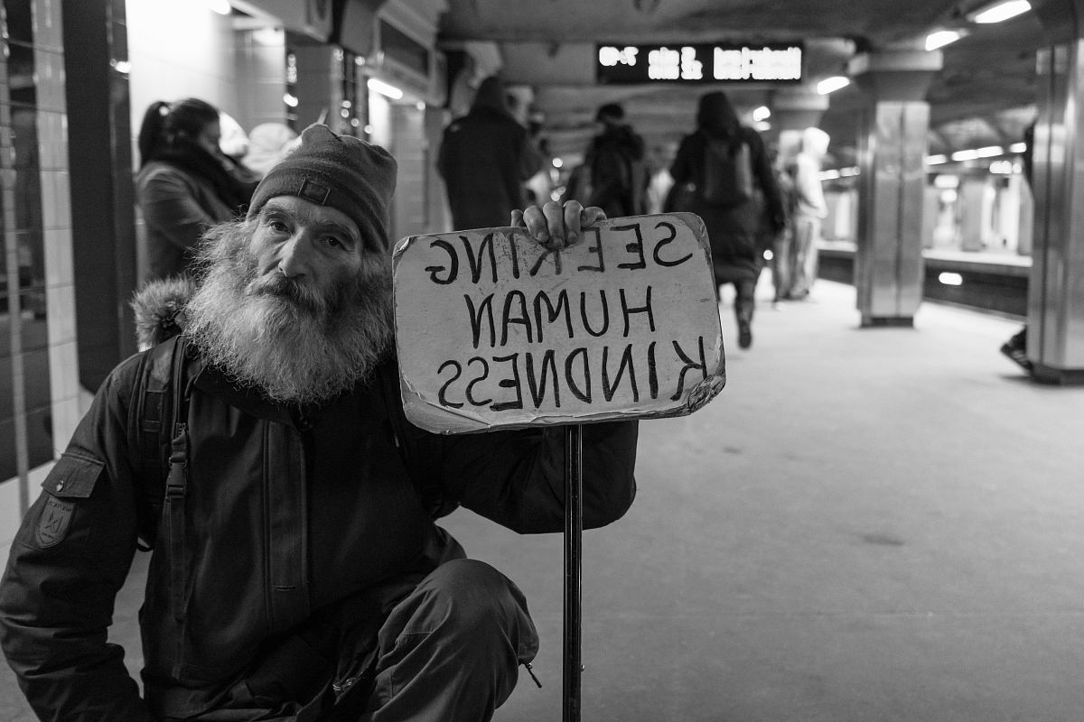 man holding card with seeking human kindness text