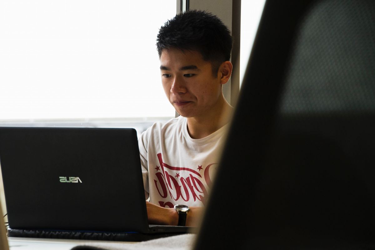 man sitting while using Asus laptop
