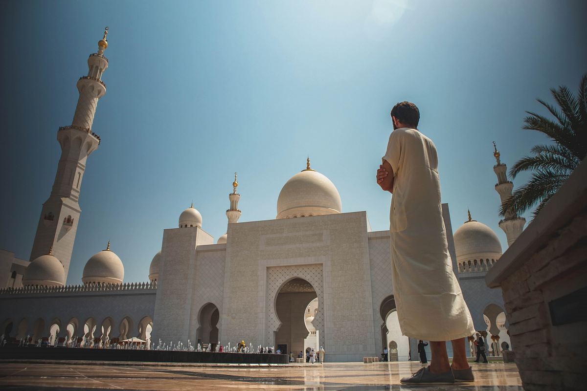 man standing near white mosque