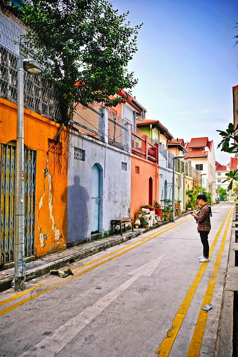 man standing on street facing wall