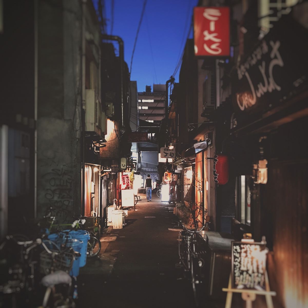 man stands on alley between buildings
