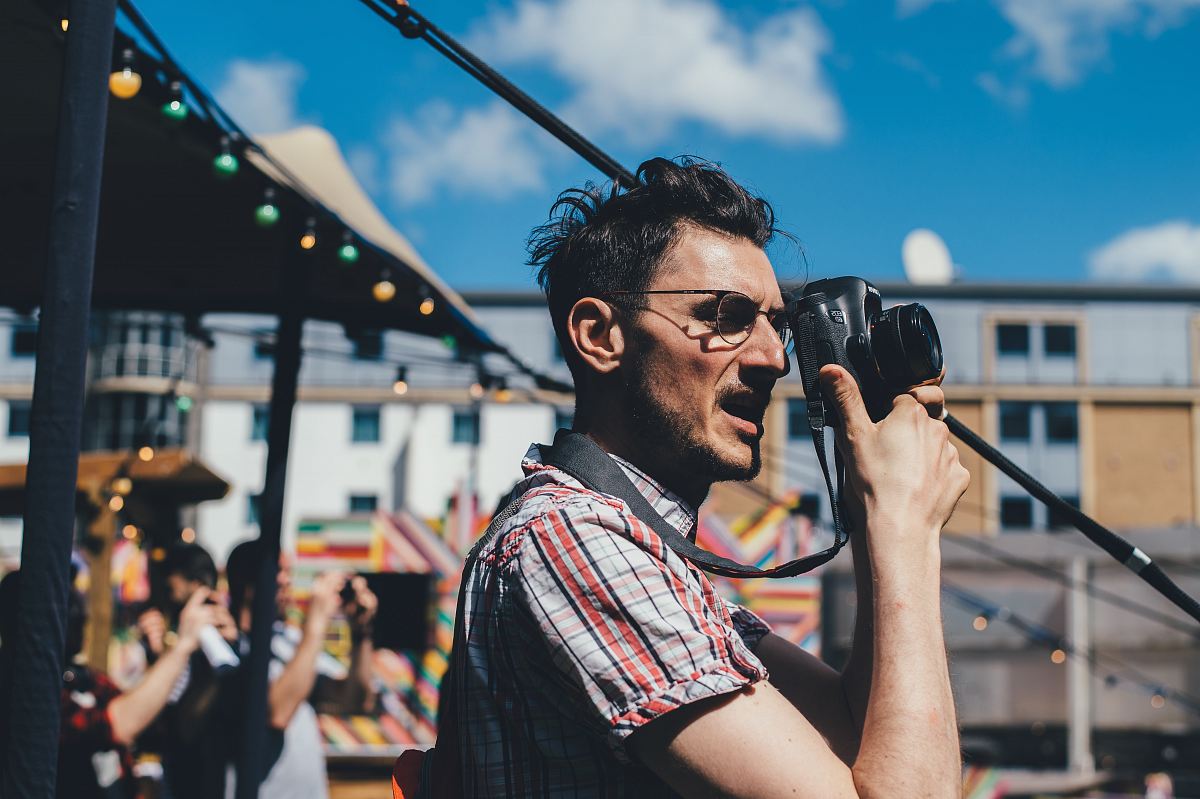 man taking a picture with DSLR camera