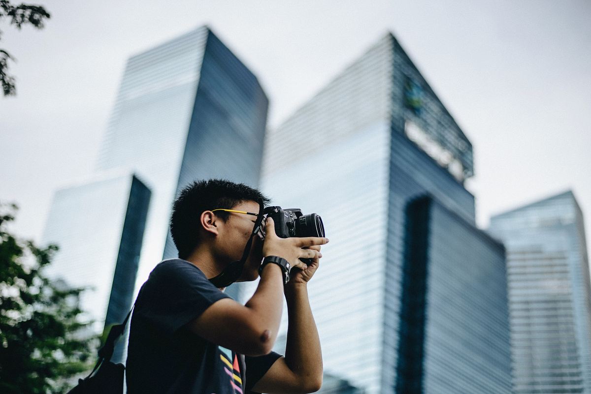man wearing black t-shirt holding DSLR camera