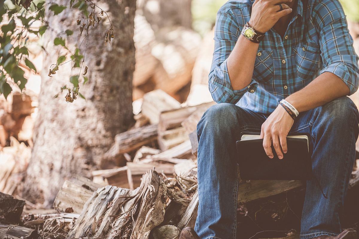 man wearing blue plaid dress shirt and blue jeans