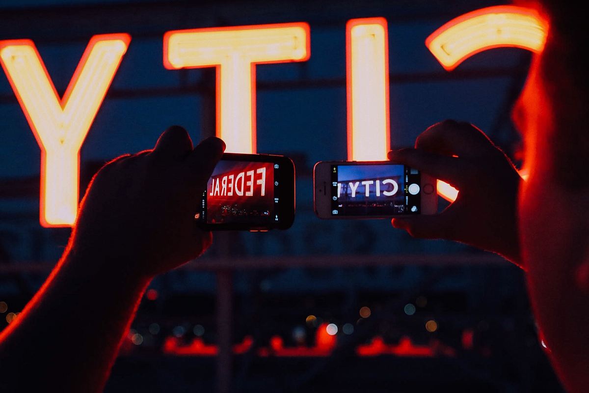 minimalist photography of person taking pictures of City Federal signages
