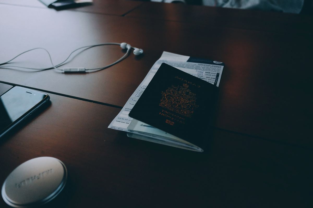 passport beside earphones on surface