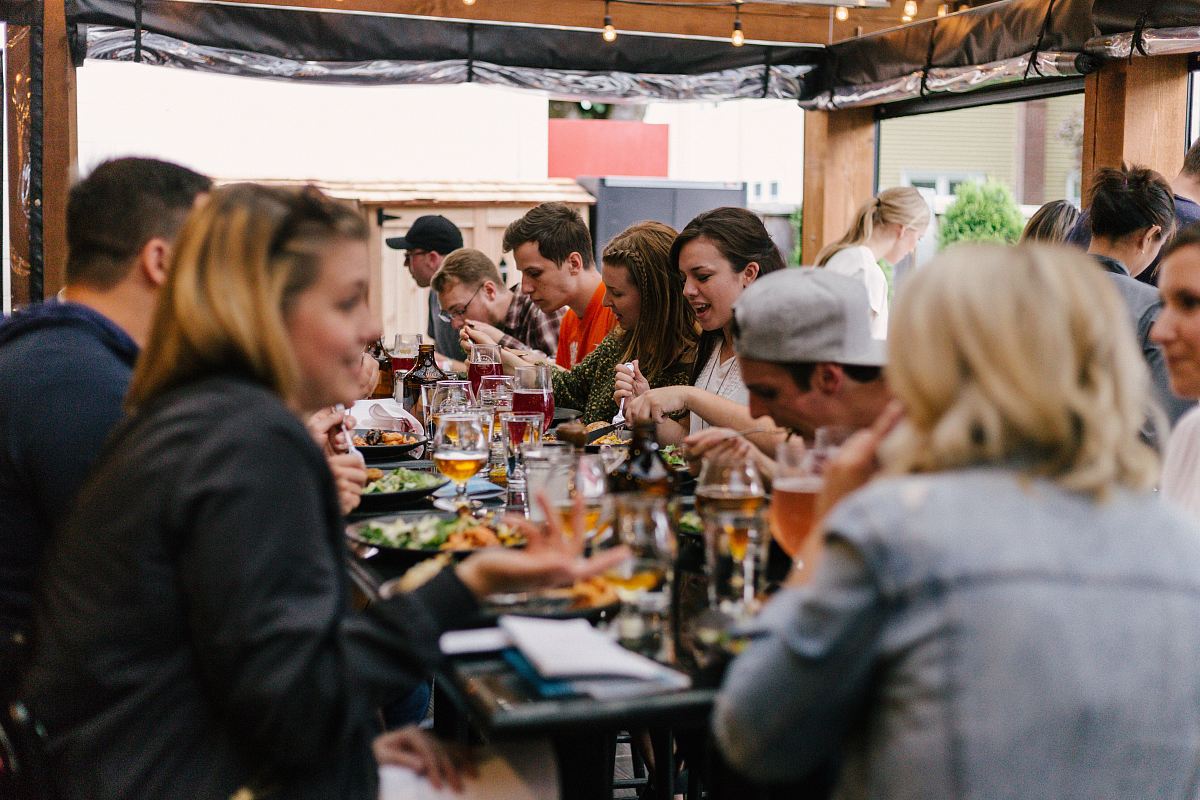 people sitting in front of table talking and eating