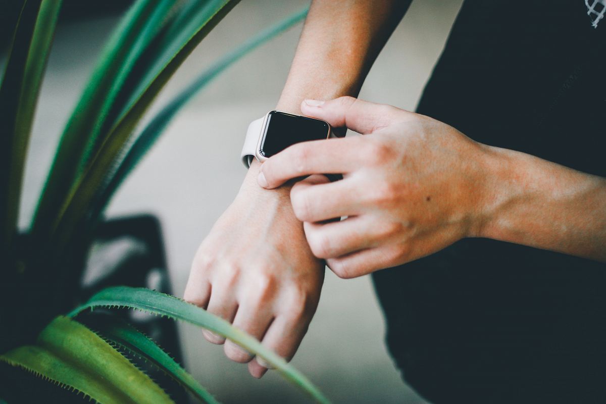 person about to use silver Apple Watch in grey Sports Band