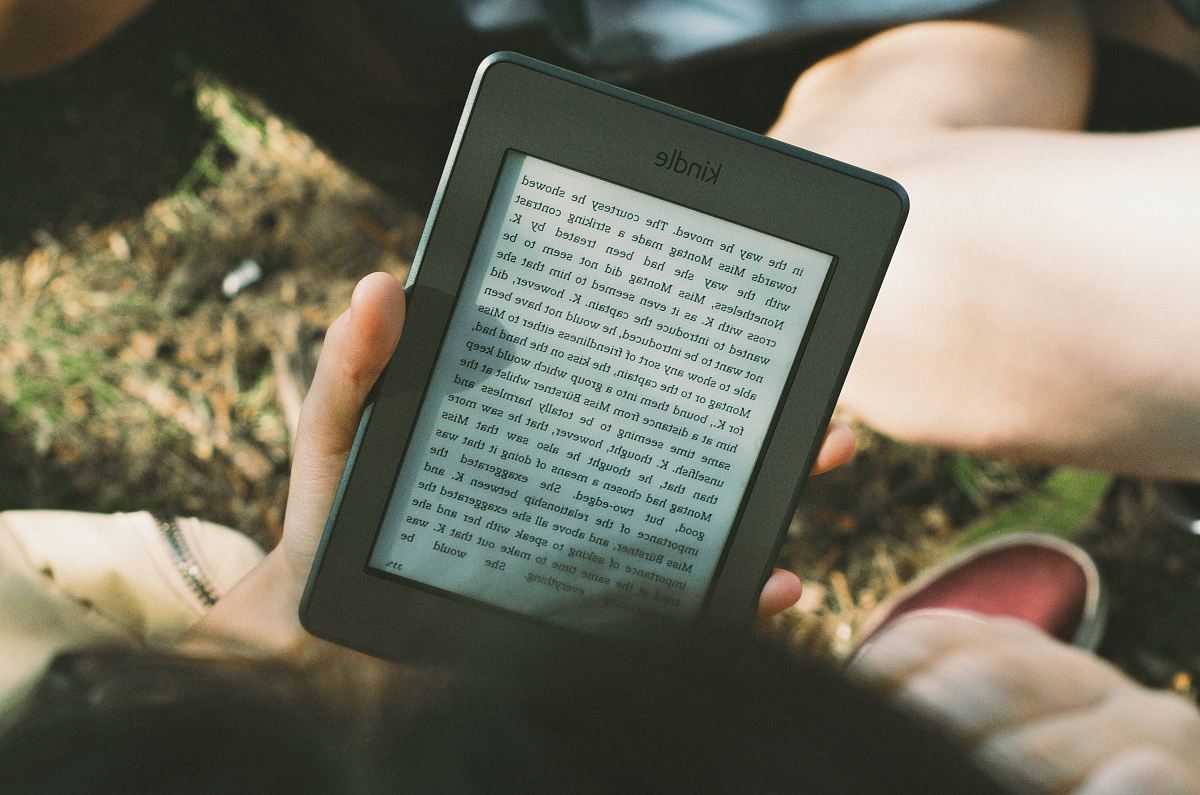 person holding black Amazon Kindle e-book reader
