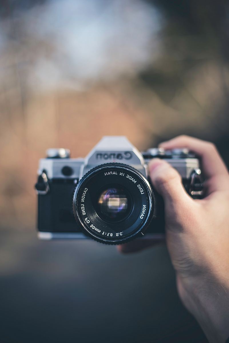 person holding black Canon DSLR camera