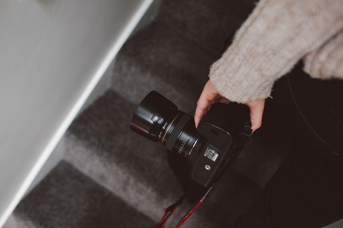 person holding black DSLR camera close-up photo