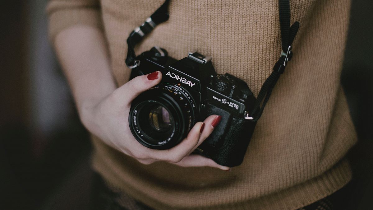 person holding black Yashica FX-9 camera